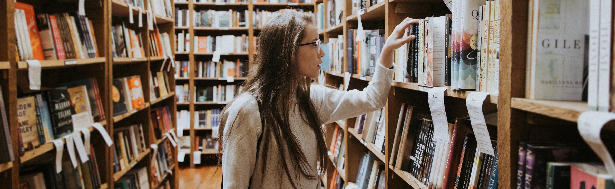 female college student looking at books